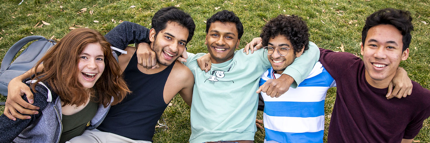 Five friends posing for photo together on the Quad.