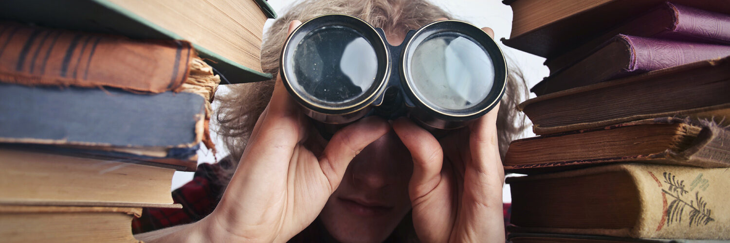 student peering through binoculars