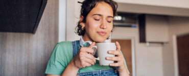young woman warming herself with a cup of tea