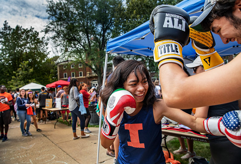 students practice sparring on the Quad during Quad Day as interested students look on