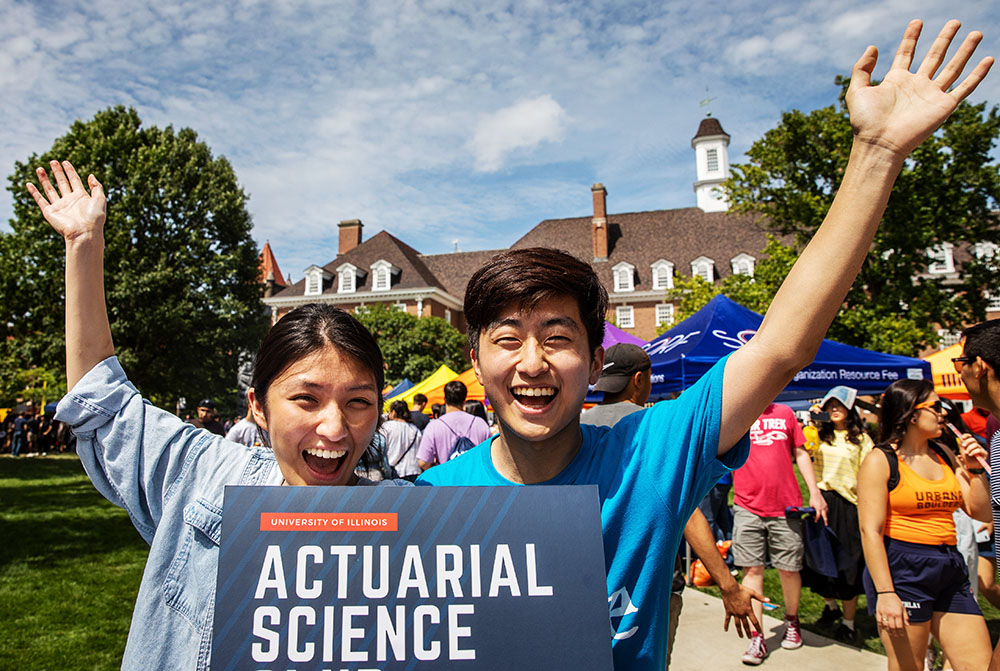 students on Quad Day hold an Actuarial Science sign to attract like-minded students