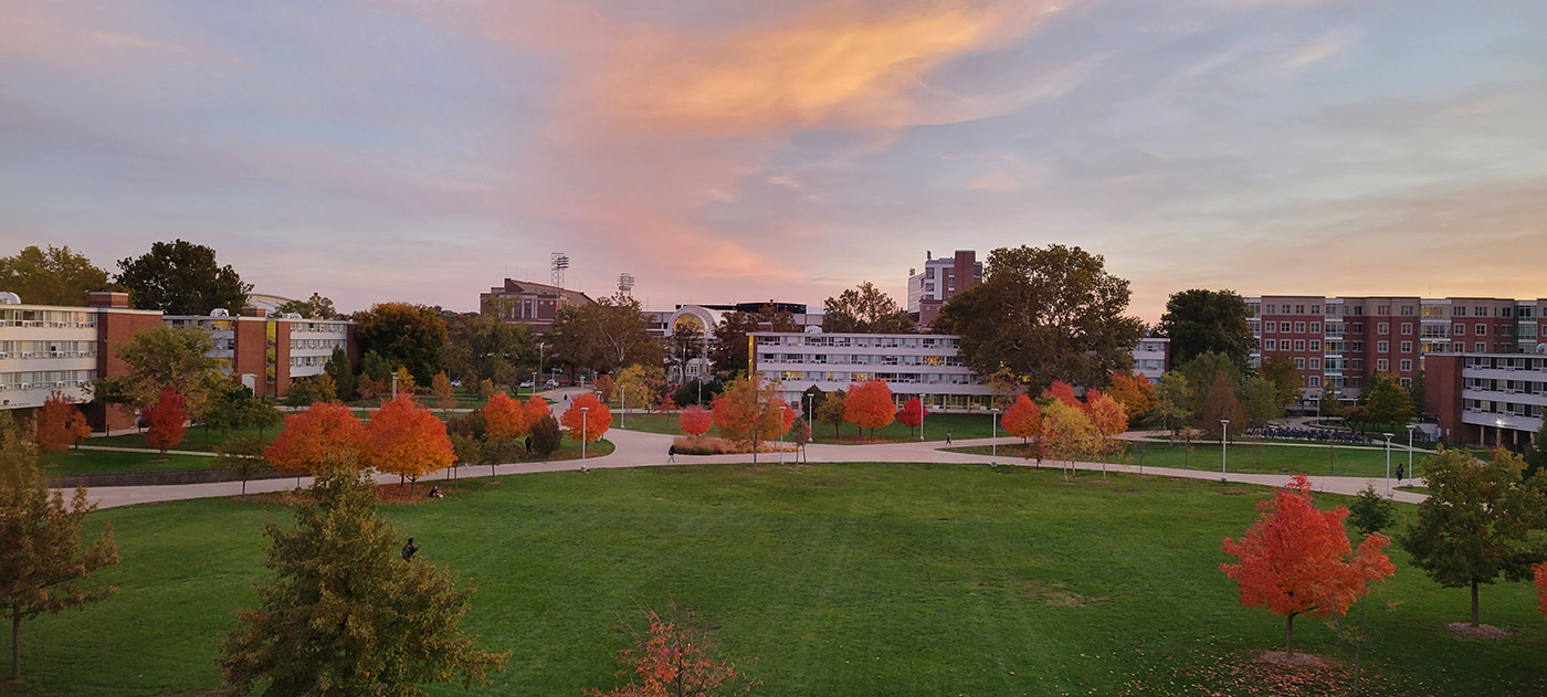 View from Angela's window overlooking the Ikenberry Quad and many red and orange colored trees. The recreation center is visible in the background
