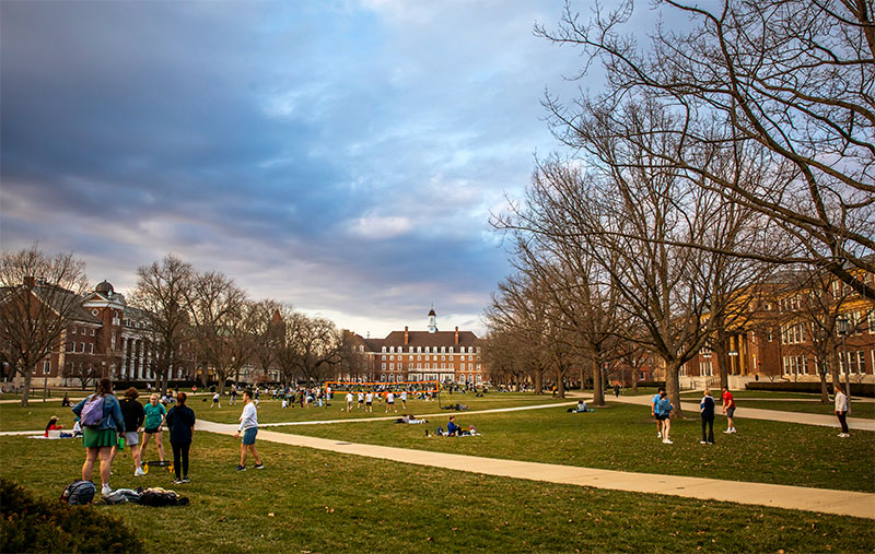 the Quad filled with students playing games on a crisp spring early evening