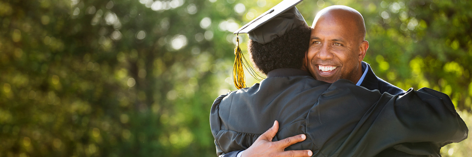 father and son embrace after a joyful high school graduation ceremony