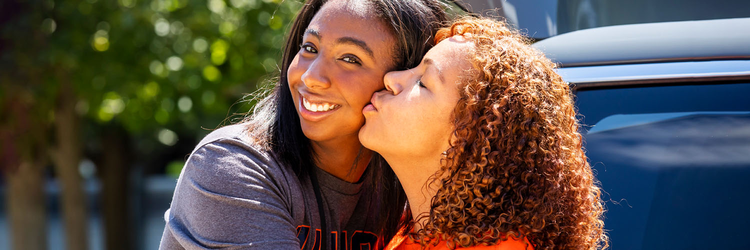 mother and daughter decked out in Illinois gear on campus move-in day on a bright sunny day