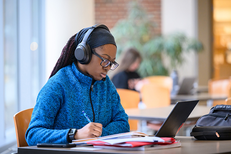 A student takes notes as she studies for finals at the Student Dining and Residential Programs Building (SDRP) at the  University of Illinois Urbana-Champaign.