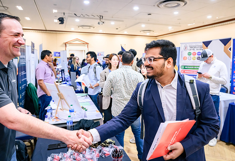 Student shaking hands with an employer at the Illini Career and Internship Fair