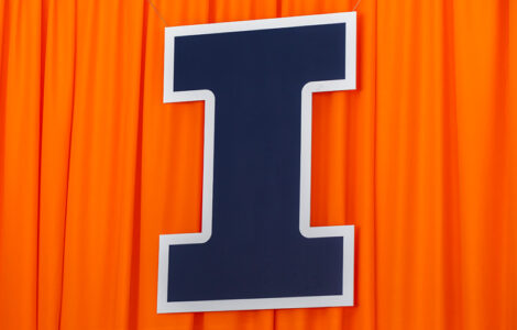 large, blue Block I hanging in front of an orange curtain at Memorial Stadium for Commencement