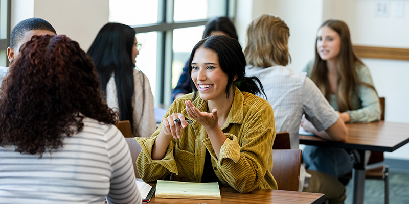 The young adult female student smiles when she meets her friends to study