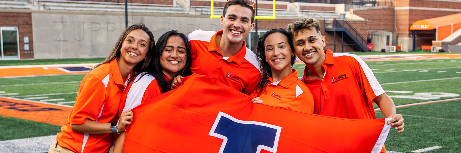 group of student holding an Illini flag help celebrate the next incoming class at Sights and Sounds, an Illinois Welcome Week event