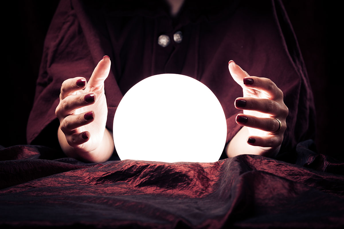 hands, brightly lit, placed around a glowing crystal ball