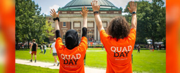 Student Engagement members with their hands up in celebration on Quad Day