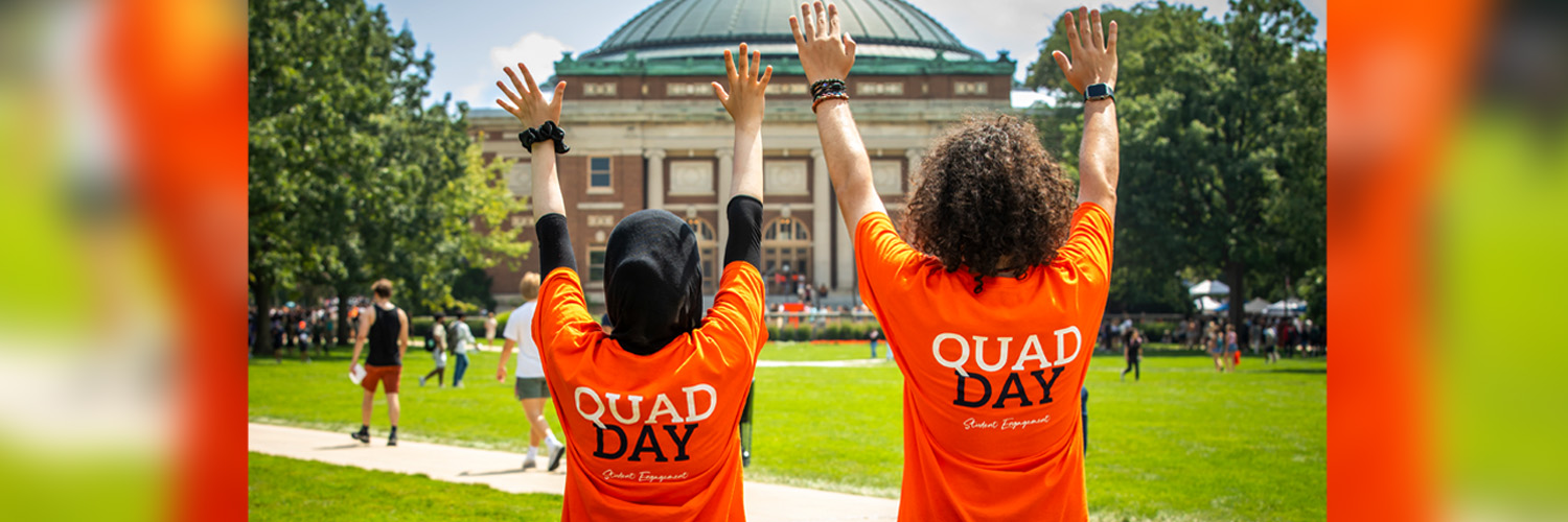 Student Engagement members with their hands up in celebration on Quad Day